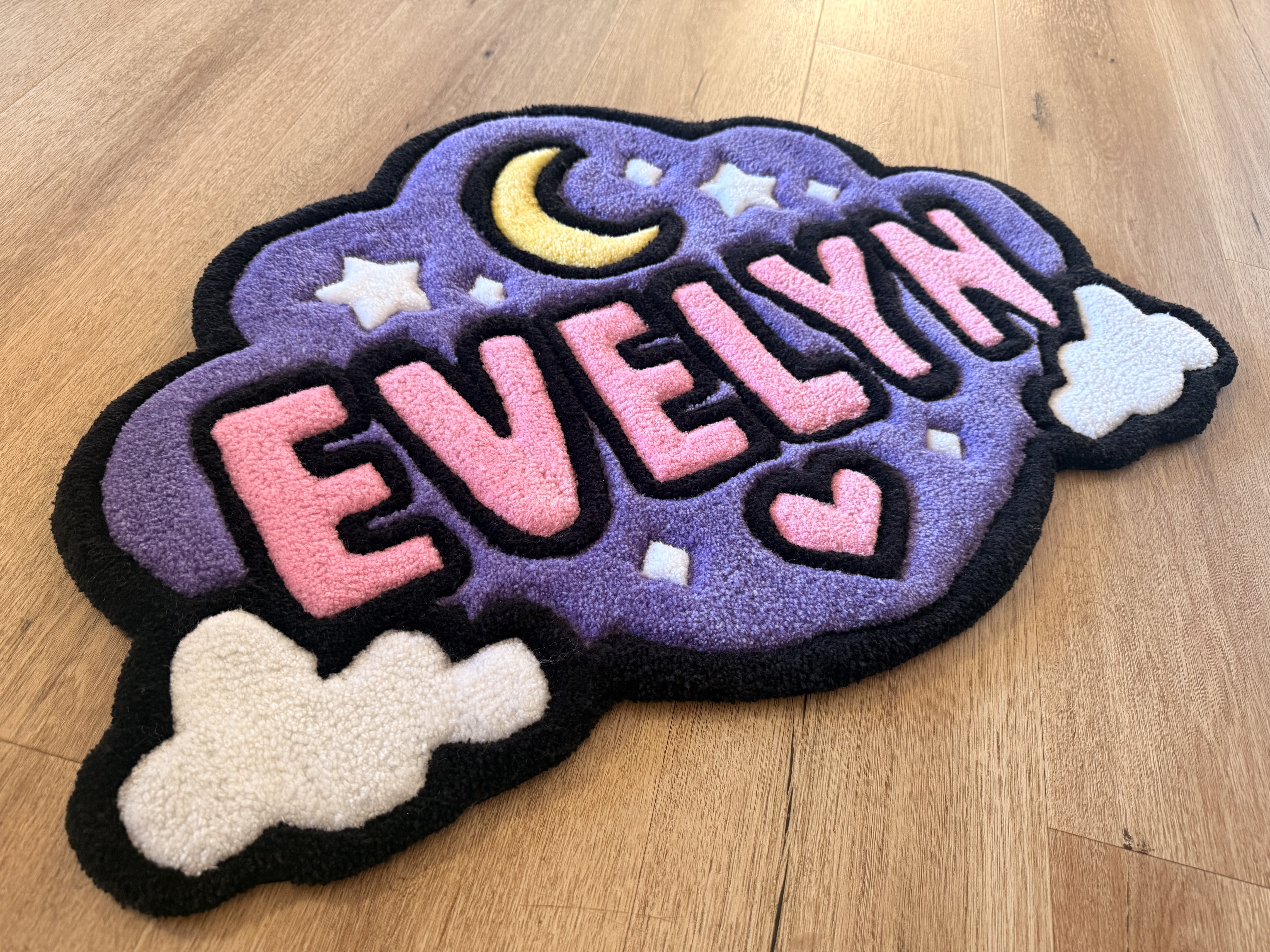 Custom Evelyn rug with pink lettering, purple background, moon, stars and clouds